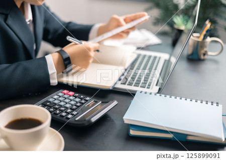 Finance bank tax expense accounting budget money businessman hand use calculator Financial calculate accountant close up calculator with graph chart write office desk Business expense analysis saving 125899091