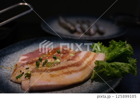 pieces of raw pork belly Sliced raw pork meat on stone plate, isolated on white background. 125899105