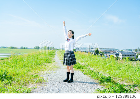 青空の下で両手を上げる女子高生 青空の下で両手を上げる女子高生 125899136