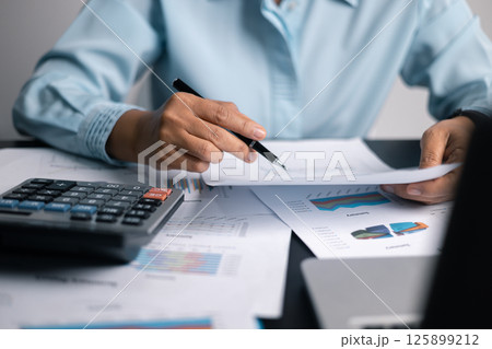 Finance bank tax expense accounting budget money businessman hand use calculator Financial calculate accountant close up calculator with graph chart write office desk Business expense analysis saving 125899212