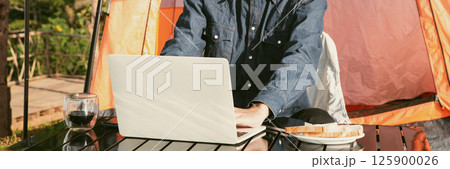Young business man working computer on peak hill. Hiker online shopping on laptop at sunset, sunrise on top mountain, freelance person remote work with digital tablet. travel vacation holiday concept Young business man working computer on peak hill. Hiker online shopping on laptop at sunset, sunrise on top mountain, freelance person remote work with digital tablet. travel vacation holiday concept 125900026