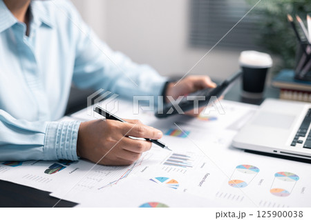 Finance bank tax expense accounting budget money businessman hand use calculator Financial calculate accountant close up calculator with graph chart write office desk Business expense analysis saving 125900038