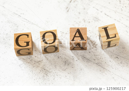 Four wooden cubes with word GOAL on white working board. 125900217