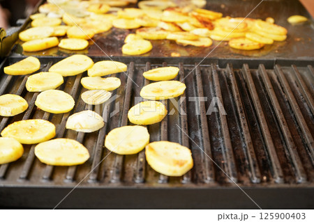 Potatoes cut into small chips grilled on electric grill, closeup detail 125900403