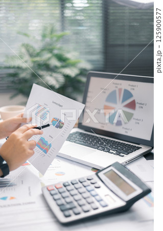 Finance bank tax expense accounting budget money businessman hand use calculator Financial calculate accountant close up calculator with graph chart write office desk Business expense analysis saving 125900577