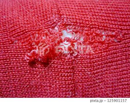 虫に食われた穴から伝線していったウールの赤いセーター 125901157