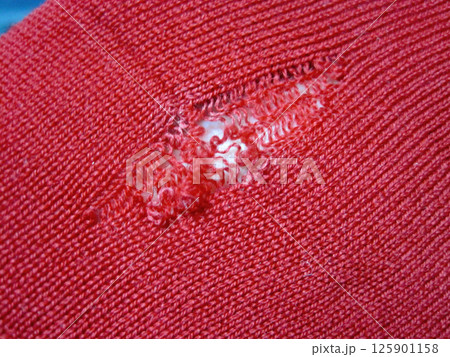 虫に食われた穴から伝線していったウールの赤いセーター 125901158