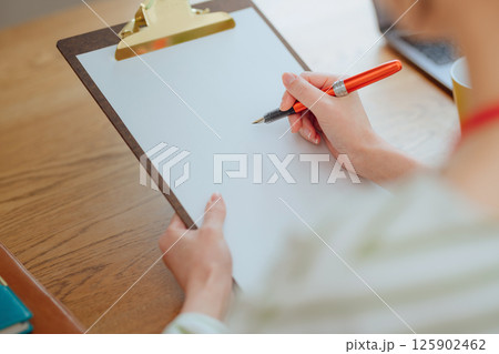 アンケートに記入する若い女性 125902462