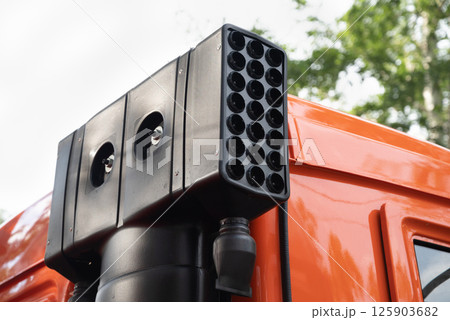 Close-up of a modern vehicle-mounted surveillance system on an orange truck. 125903682