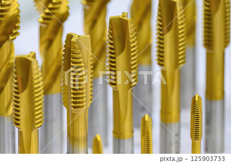 Close up scene the golden coating tap tool for CNC machine. Close up scene the golden coating tap tool for CNC machine. 125903733
