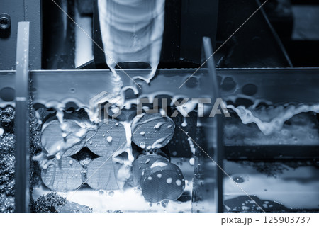 The band saw cutting machine cutting the group of metal shaft parts with coolant method in the light blue scene. The band saw cutting machine cutting the group of metal shaft parts with coolant method in the light blue scene. 125903737