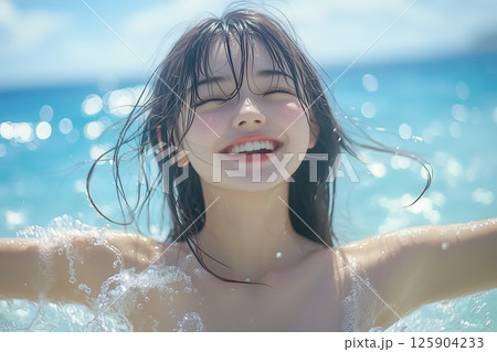 うれしそうな笑顔の若い女性が夏の海で遊んでいる 125904233
