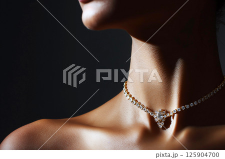 A close-up image of a woman wearing a simple yet elegant necklace, highlighting sophistication and minimalist jewelry design often seen in fashion and luxury accessories. 125904700