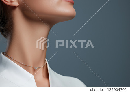 A close-up image of a woman wearing a simple yet elegant necklace, highlighting sophistication and minimalist jewelry design often seen in fashion and luxury accessories. 125904702