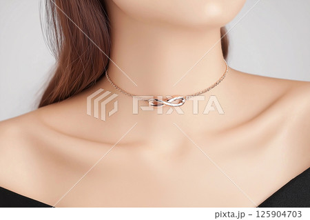 A close-up image of a woman wearing a simple yet elegant necklace, highlighting sophistication and minimalist jewelry design often seen in fashion and luxury accessories. 125904703