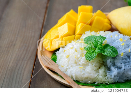 Ripe Mango Sticky Rice is a classic Thai dessert that combines the natural sweetness of ripe mangoes with rich, creamy coconut-infused sticky rice Ripe Mango Sticky Rice is a classic Thai dessert that combines the natural sweetness of ripe mangoes with rich, creamy coconut-infused sticky rice 125904788