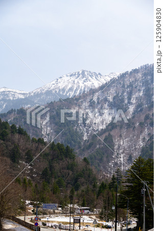 Snow-Dusted Mountains and Evergreen Forests Under a Pale Winter Sky, Japanese Alps. kamikochi nagano Snow-Dusted Mountains and Evergreen Forests Under a Pale Winter Sky, Japanese Alps. kamikochi nagano 125904830