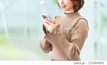 スマートフォンを使う笑顔の女性・ビジネスウーマン 125904841