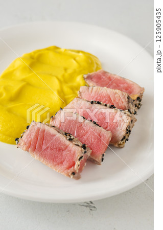 Sesame-crusted sliced tuna with cauliflower curry puree on modern white plate Sesame-crusted sliced tuna with cauliflower curry puree on modern white plate 125905435