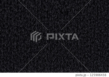 Dark textured knit fabric showcasing close-up of intricate knitting patterns Dark textured knit fabric showcasing close-up of intricate knitting patterns 125906438