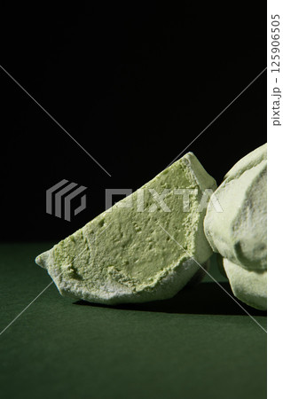 Natural apple light green marshmallow in a section on a dark background. Studio photo. Close-up. 125906505
