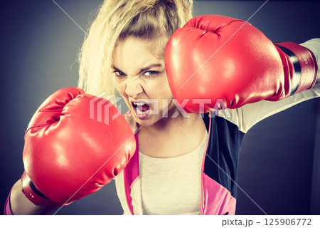 Angry woman wearing boxing gloves Angry woman wearing boxing gloves 125906772