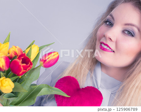 Woman holds tulips and red heart Woman holds tulips and red heart 125906789