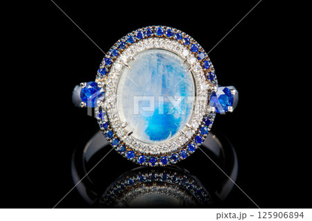 white gold ring with moonstone, sapphire, diamonds on black background 125906894
