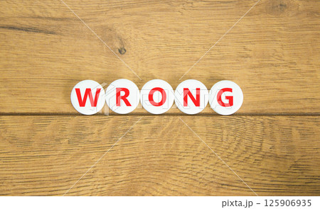 Wrong symbol. Concept word Wrong on beautiful white pills circles. Beautiful wooden table wooden background. Business lifestyle wrong concept. Copy space. 125906935