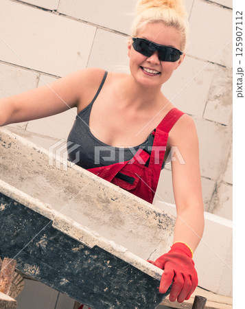 Female builder working build new house 125907112