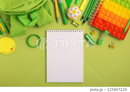 Mockup from notebook with school stationery supplies on green background. Top view. Copy space Mockup from notebook with school stationery supplies on green background. Top view. Copy space 125907220