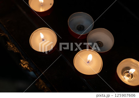 Burning Tealight Candles in Dark Interior Burning Tealight Candles in Dark Interior 125907606