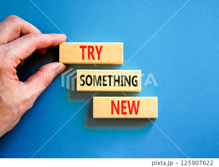 Try something new symbol. Concept words Try something new on beautiful block. Businessman's hand. Beautiful blue background. Business motivational lifestyle try something new concept. Copy space. 125907622