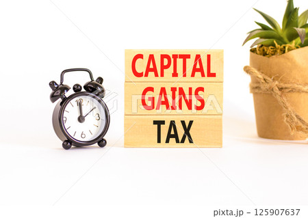 Capital gains tax symbol. Concept words Capital gains tax on beautiful wooden block. Black alarm clock. Beautiful white background. Business and capital gains tax concept. Copy space. Capital gains tax symbol. Concept words Capital gains tax on beautiful wooden block. Black alarm clock. Beautiful white background. Business and capital gains tax concept. Copy space. 125907637