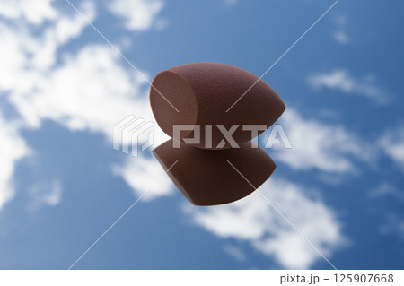 Brown cut sponge on glass. Blue sky with white clouds. Horizontal photo. Brown cut sponge on glass. Blue sky with white clouds. Horizontal photo. 125907668