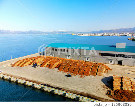 春の北海道函館市函館港で材木の搬出作業の風景を空撮 125908050