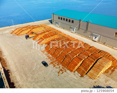 春の北海道函館市函館港で材木の搬出作業の風景を空撮 125908054