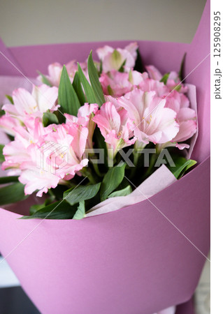 delicate bouquet with pink alstroemerias in wrapping, close-up 125908295