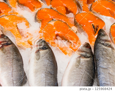Freshly prepared fish displayed on ice at a vibrant market Freshly prepared fish displayed on ice at a vibrant market 125908424