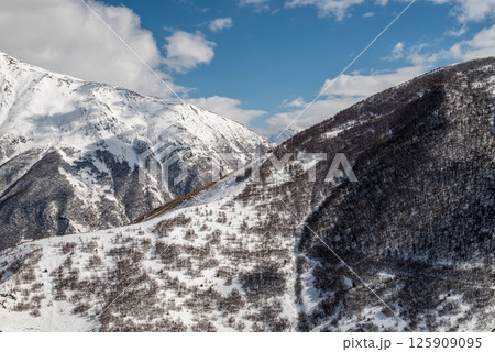 Snowcapped peaks of Caucasus mountains along the Georgian Military Road, major route from Georgia to Russia 125909095