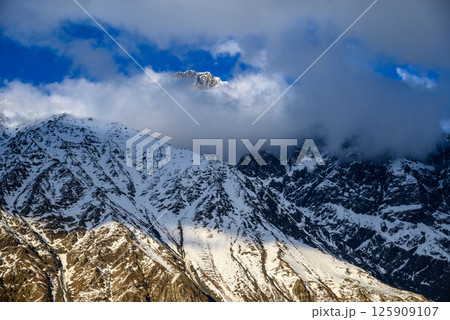 Snowcapped peaks of Caucasus mountains along the Georgian Military Road, major route from Georgia to Russia 125909107