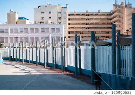 Urban architecture with modern fences and buildings under a clear sky. 125909682