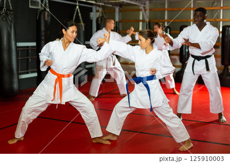 Man and women sparring during karate training Man and women sparring during karate training 125910003