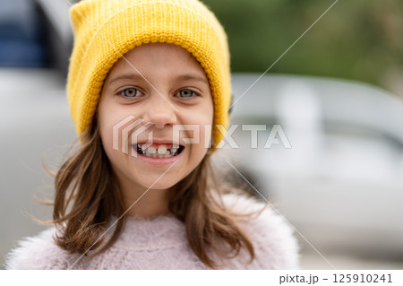 Smiling girl with bright blue eyes in yellow knit 125910241