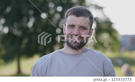 A cheerful man is enjoying a sunny day in a beautiful park, surrounded by the lovely, vibrant nature A cheerful man is enjoying a sunny day in a beautiful park, surrounded by the lovely, vibrant nature 125910773