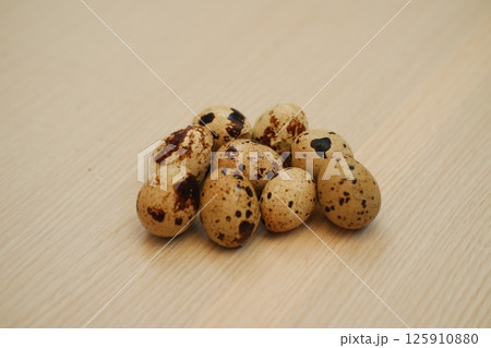 Group of Fresh Quail Eggs on Wooden Surface 125910880
