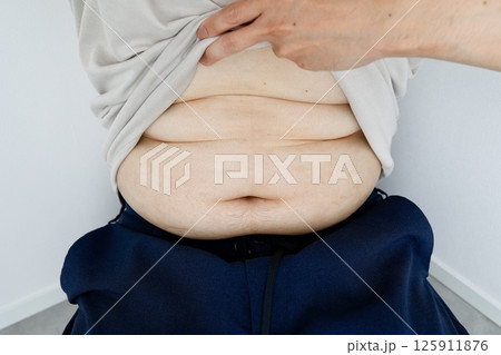 三段腹の中年男性のお腹のクローズアップ 125911876
