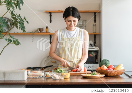 キッチンで料理をする若いアジア人女性(切る・包丁・クッキング・手料理) キッチンで料理をする若いアジア人女性(切る・包丁・クッキング・手料理) 125913410