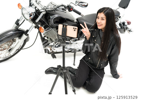 スマホカメラの前でピースするモトブロガー 125913529