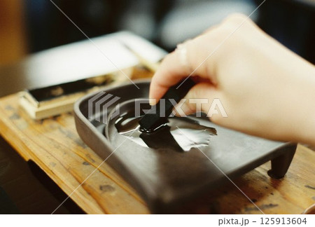 日本の伝統文化である書道の準備のために墨をする手元のクローズアップ 125913604